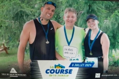 Trois participants réunis autour d’une pancarte de course