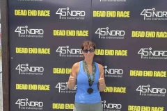 Participante devant le panneau de la course Dead End Race