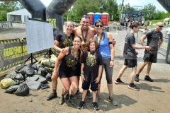 Trois participantes devant l’arche de course à obstacles