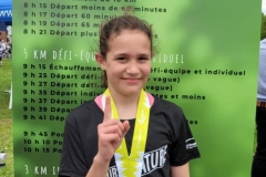 Jeune participant présentant sa médaille de course