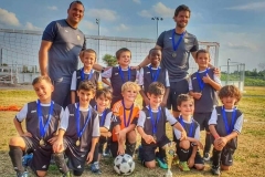 Équipe de jeunes joueurs de soccer avec deux adultes sur le terrain