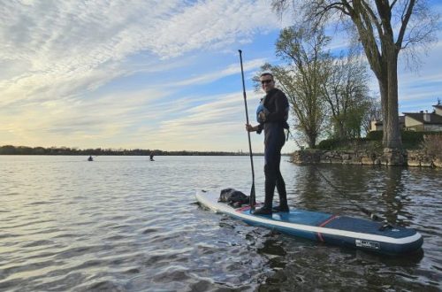 Personne sur une planche à pagaie près de la rive